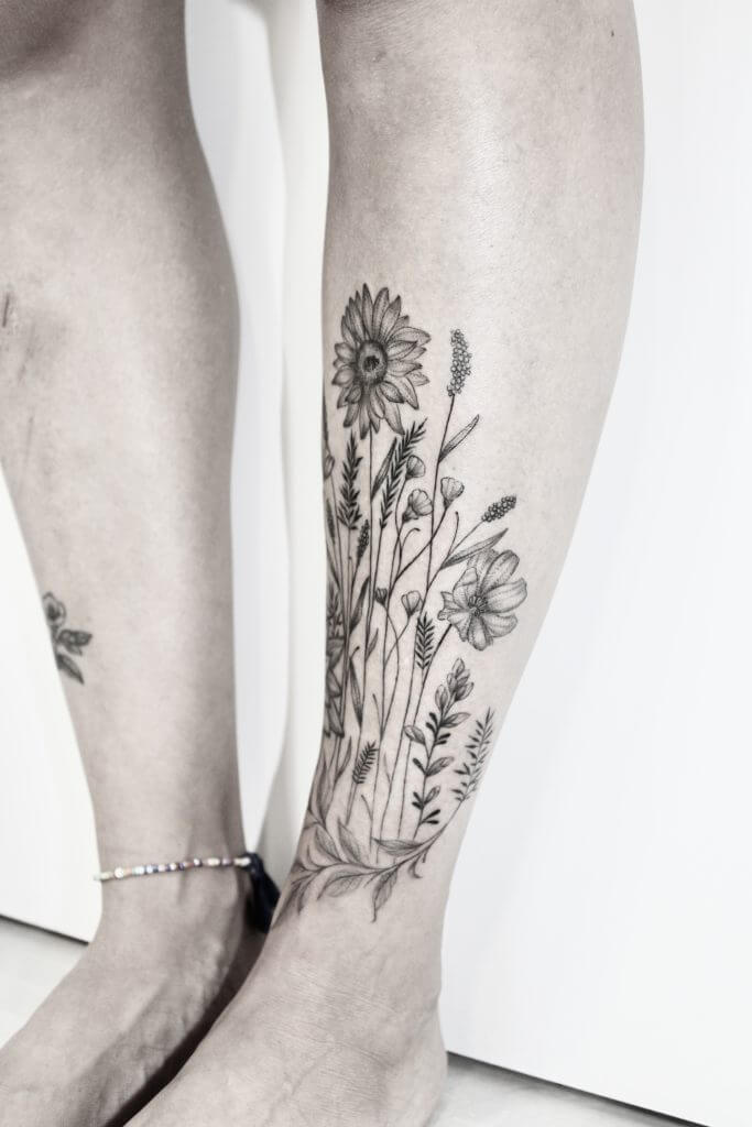 tattoo noir floral encre noire fleur tattoo tatouage féminin finesse tatou tibia tattoo femme fleurs des champs tattoo tattoo cosmos tattoo tournesol